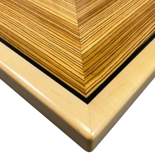 Brookline “Qtr. Zebrawood Veneer” in Box Pattern with ¼” Black Printed Accent Stripe and Natural Maple Wood Edge